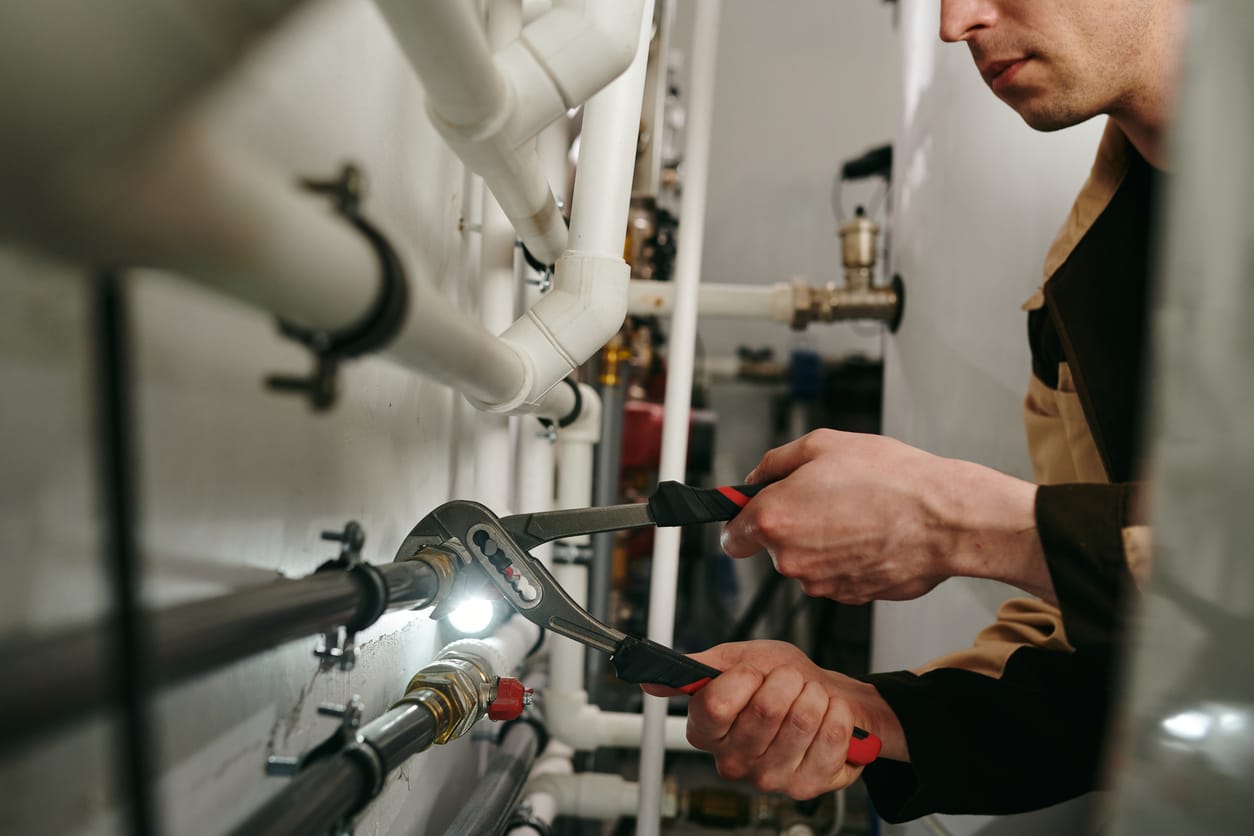 Plumbers maintaining commercial plumbing pipes in Roswell