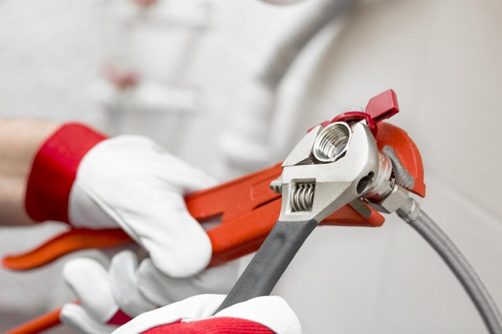 Plumber holding pipe wrenches for an emergency repair in Roswell