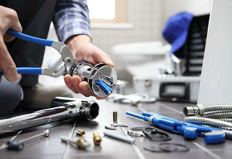 Technician repairing a plumbing fixture with professional tools in Roswell