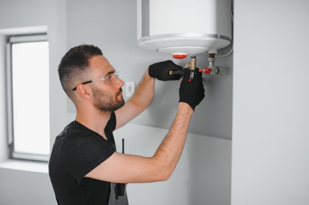 Technician performing water heater maintenance in Roswell